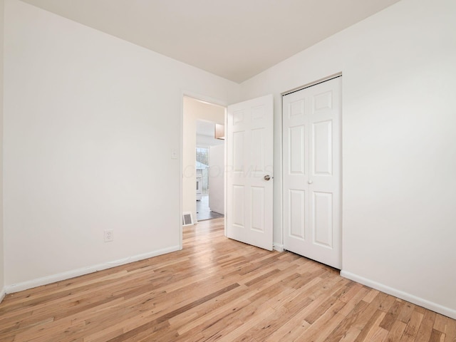 unfurnished bedroom with light hardwood / wood-style flooring and a closet