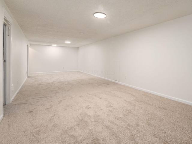 spare room featuring carpet floors and a textured ceiling