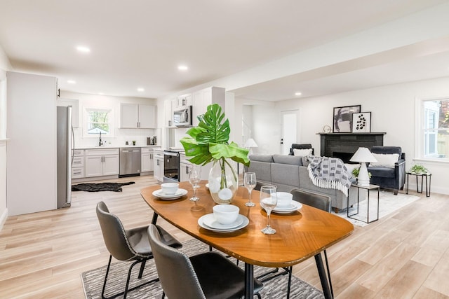 dining room featuring light hardwood / wood-style floors, sink, and a wealth of natural light