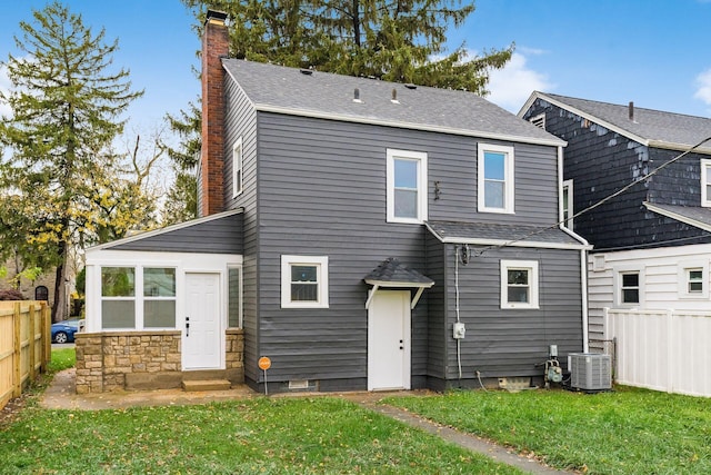 back of property featuring a lawn and central air condition unit