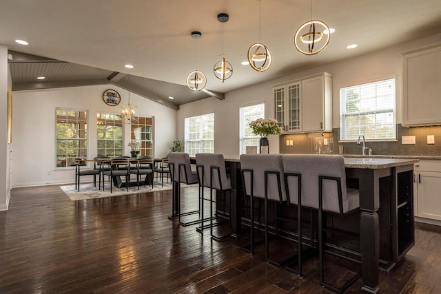 kitchen featuring a healthy amount of sunlight, hanging light fixtures, and lofted ceiling