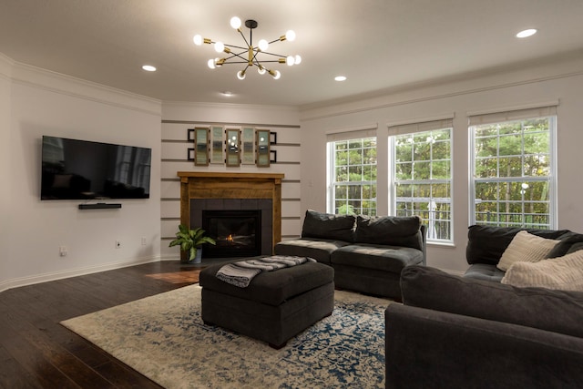 living room featuring a notable chandelier, a fireplace, dark hardwood / wood-style floors, and ornamental molding