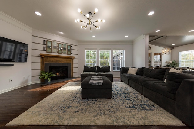 living room featuring a fireplace, dark wood-type flooring, a wealth of natural light, and a chandelier