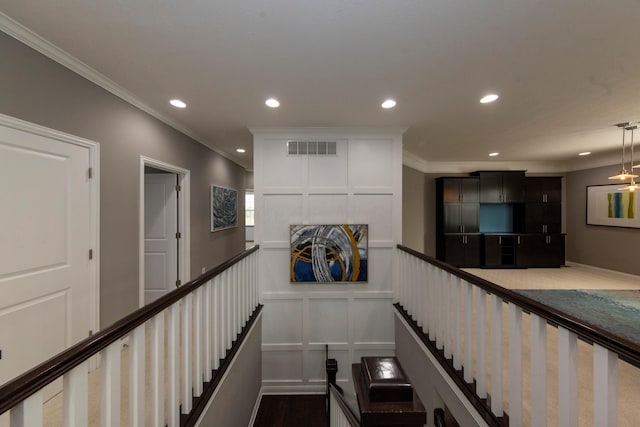 staircase featuring wood-type flooring and ornamental molding