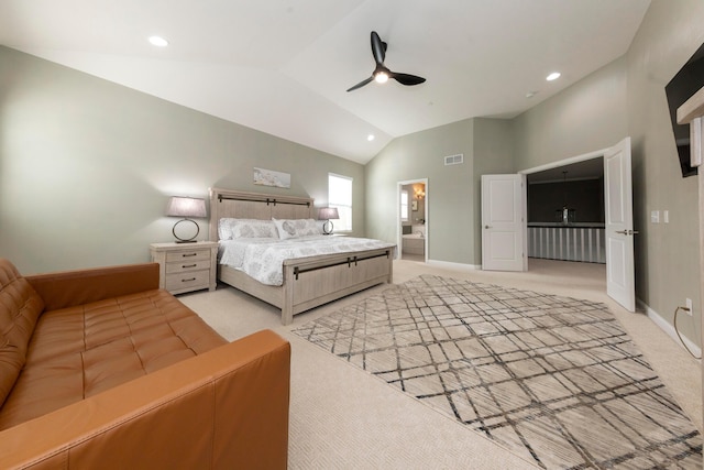 bedroom with ceiling fan, light colored carpet, high vaulted ceiling, and ensuite bath