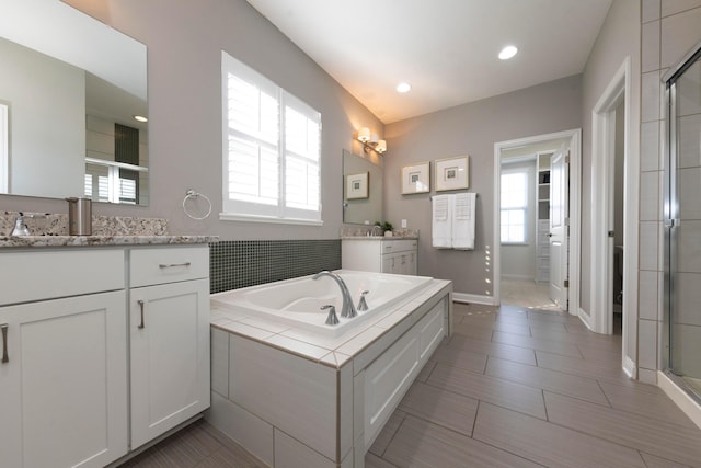 bathroom with shower with separate bathtub and vanity