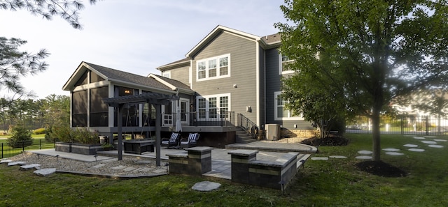 back of house with a sunroom, a patio area, a yard, and a deck