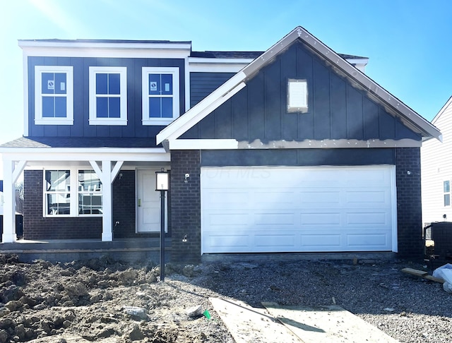 view of front facade featuring brick siding, board and batten siding, covered porch, and an attached garage