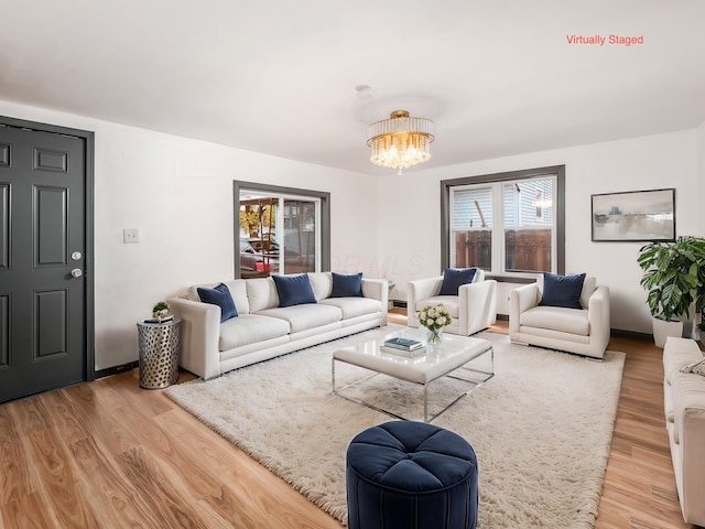 living room with light hardwood / wood-style flooring and a notable chandelier