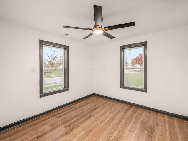 unfurnished room featuring plenty of natural light, light hardwood / wood-style floors, and ceiling fan