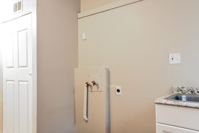 clothes washing area with electric dryer hookup, hookup for a washing machine, and sink