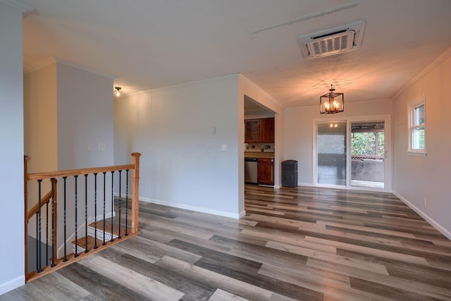 spare room featuring a chandelier, wood-type flooring, and ornamental molding