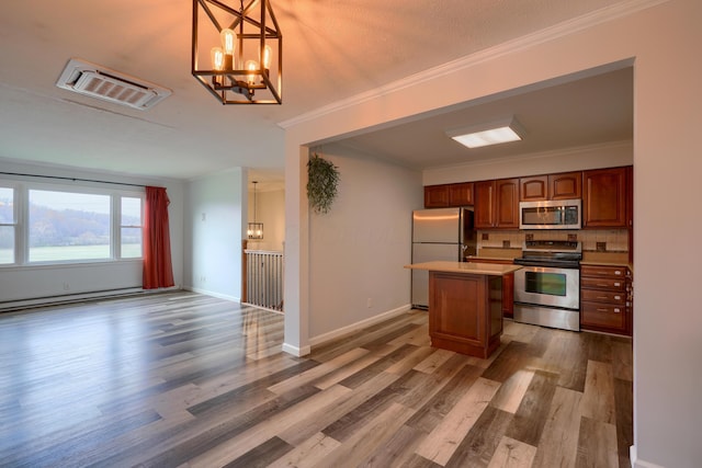 kitchen featuring pendant lighting, a center island, stainless steel appliances, and hardwood / wood-style floors