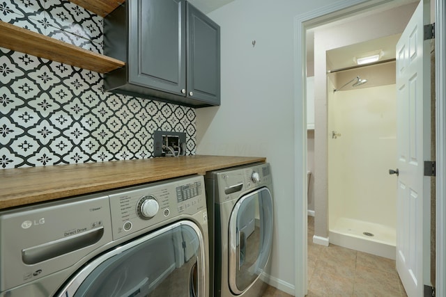 laundry area featuring cabinets, separate washer and dryer, and light tile patterned floors