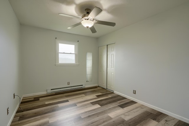 empty room featuring a baseboard radiator, light hardwood / wood-style flooring, and ceiling fan