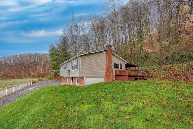 view of home's exterior featuring a deck and a lawn