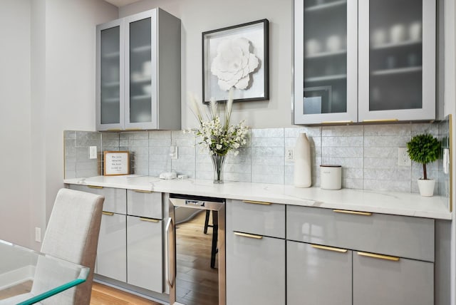 kitchen with gray cabinets, light stone counters, beverage cooler, and light hardwood / wood-style floors