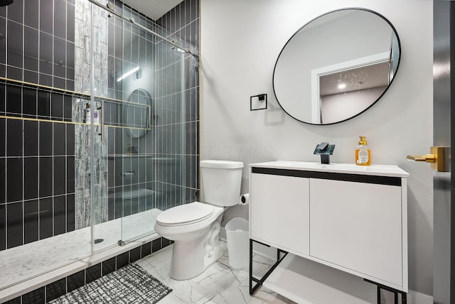 bathroom featuring vanity, a shower with shower door, and toilet