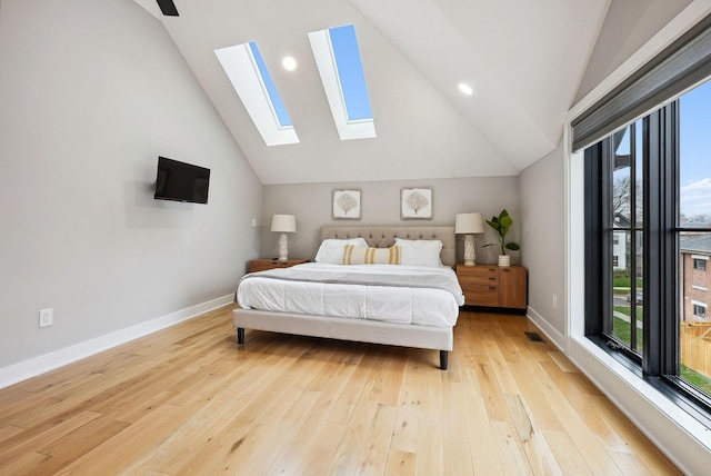 bedroom with ceiling fan, light hardwood / wood-style floors, high vaulted ceiling, and multiple windows