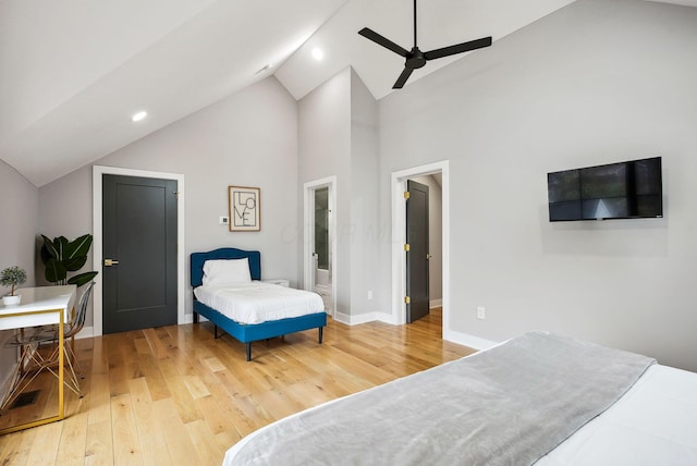 bedroom with connected bathroom, ceiling fan, high vaulted ceiling, and hardwood / wood-style flooring