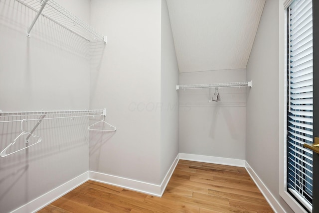 walk in closet with hardwood / wood-style flooring and lofted ceiling