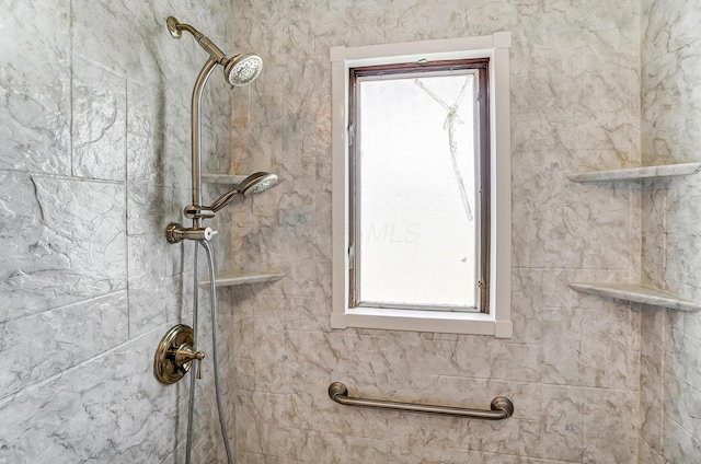 interior details featuring tiled shower