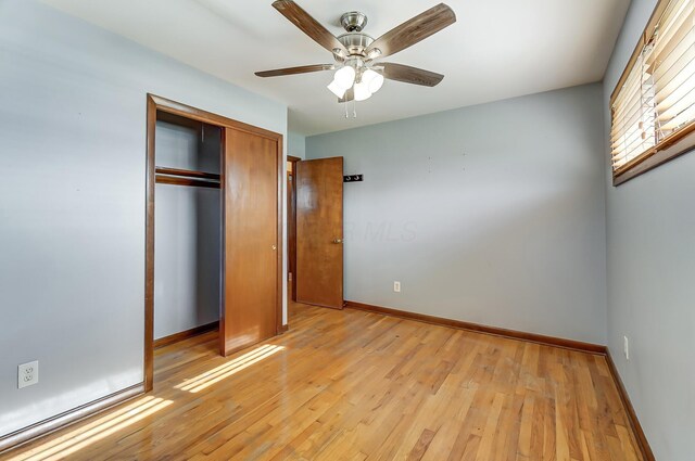 unfurnished bedroom featuring ceiling fan, light hardwood / wood-style floors, and a closet