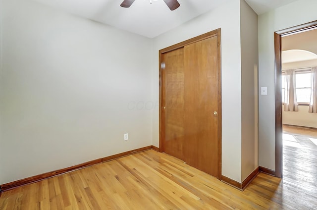 unfurnished bedroom with ceiling fan, light hardwood / wood-style floors, and a closet