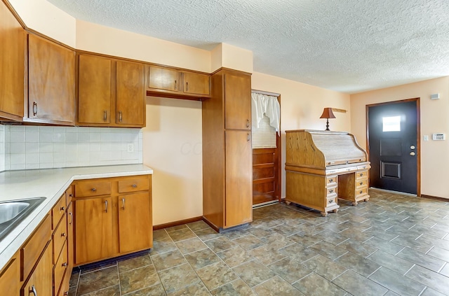 kitchen featuring decorative backsplash and a textured ceiling