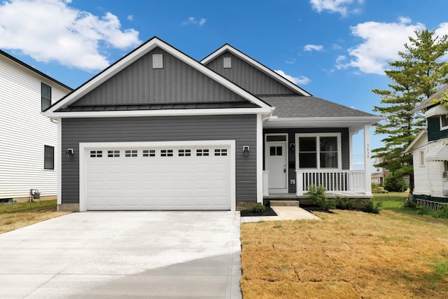 view of front of home featuring a porch, a garage, and a front lawn