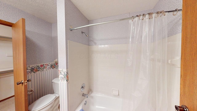 bathroom featuring shower / bath combo, toilet, and a textured ceiling