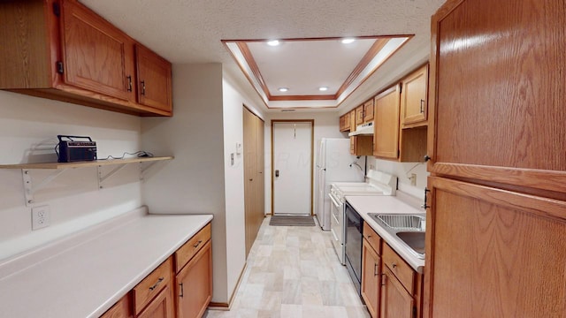 kitchen featuring crown molding, stainless steel electric range oven, sink, and a tray ceiling