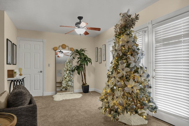 living area with carpet flooring and ceiling fan