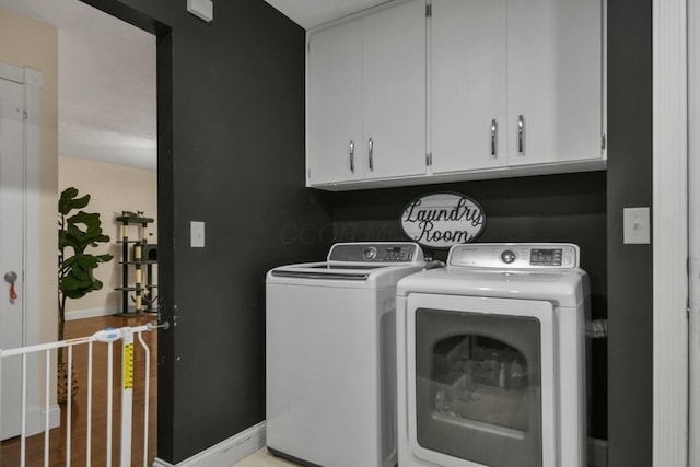 laundry room with cabinets and washing machine and clothes dryer