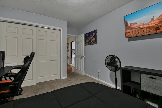 carpeted office featuring a textured ceiling