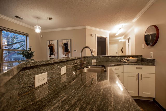 39 Buttles Ave Unit 39, Columbus, OH 43215 - kitchen with ornamental molding, a textured ceiling, dark stone counters, decorative light fixtures, and white cabinets