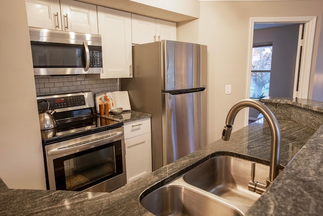 39 Buttles Ave Unit 39, Columbus, OH 43215 - kitchen featuring stainless steel appliances, white cabinets, backsplash, and dark stone countertops