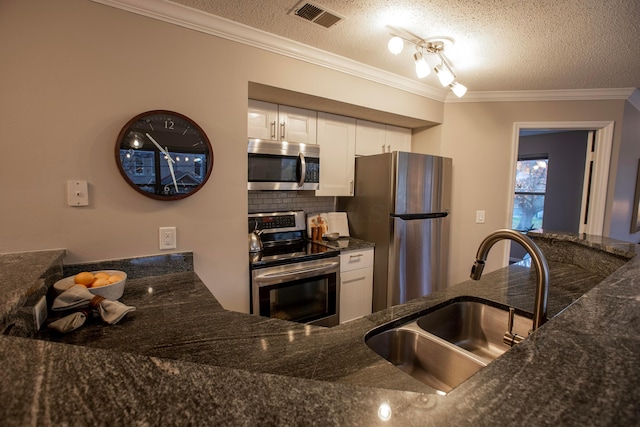 39 Buttles Ave Unit 39, Columbus, OH 43215 - kitchen with appliances with stainless steel finishes, white cabinetry, ornamental molding, a textured ceiling, and dark stone countertops