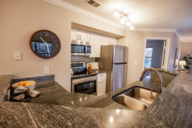 39 Buttles Ave Unit 39, Columbus, OH 43215 - kitchen with appliances with stainless steel finishes, ornamental molding, white cabinetry, a textured ceiling, and dark stone counters