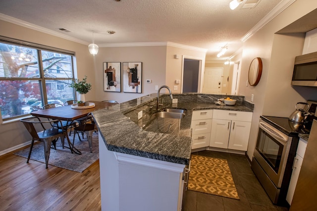 39 Buttles Ave Unit 39, Columbus, OH 43215 - kitchen with stainless steel appliances, white cabinetry, crown molding, a textured ceiling, and dark stone countertops