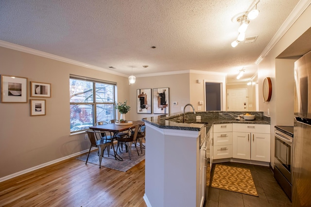 39 Buttles Ave Unit 39, Columbus, OH 43215 - kitchen featuring stainless steel electric stove, a textured ceiling, a peninsula, ornamental molding, and white cabinets