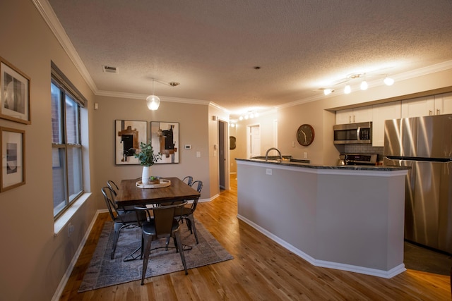 39 Buttles Ave Unit 39, Columbus, OH 43215 - dining space featuring wood finished floors, a textured ceiling, and ornamental molding