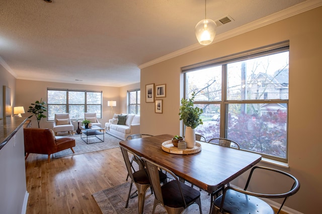 39 Buttles Ave Unit 39, Columbus, OH 43215 - dining room featuring light wood-style flooring, crown molding, and a textured ceiling