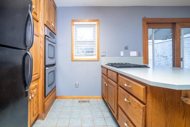 kitchen with kitchen peninsula, light tile patterned floors, and stainless steel appliances