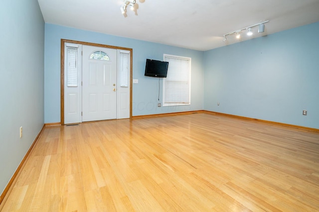 entryway featuring rail lighting, light hardwood / wood-style floors, and a wealth of natural light