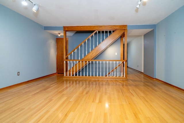 unfurnished living room with light wood-type flooring and rail lighting