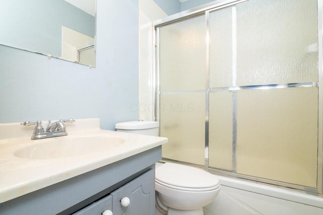 full bathroom featuring vanity, toilet, and combined bath / shower with glass door