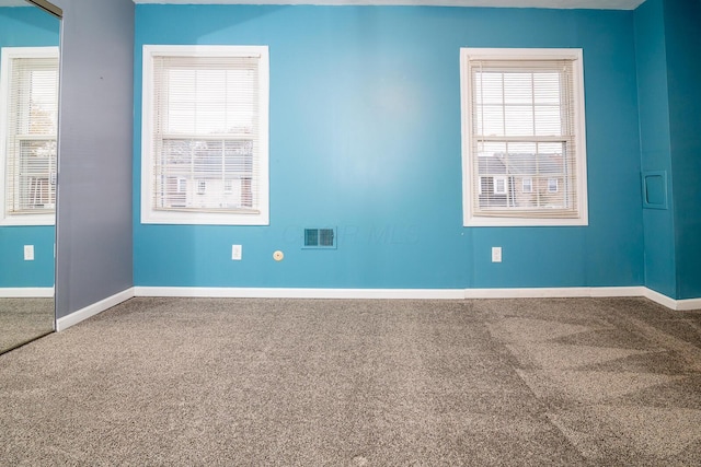 carpeted spare room with a healthy amount of sunlight