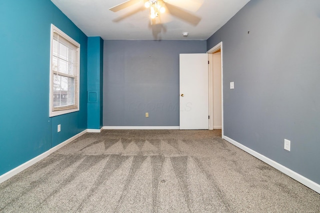 carpeted empty room featuring ceiling fan