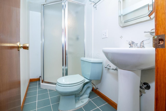 bathroom featuring tile patterned floors, toilet, and a shower with door